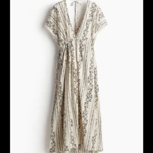 Beige blommig omlottklänning - Beige omlottklänning, endast använd ett fåtal gånger, nyskick. Från H&M. Storlek L men går att justera storleken från sidorna, tajtare eller lösare. Så funkar som M också