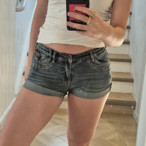 Mörkblå jeansshorts  - Skit snygga mörklblå vintage shorts! Byxbenen går att rulla ner om man vill ha de längre. Älskar dessa! Stl 164, av märket Geisha, stretchiga.