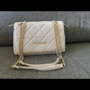 Beige quiltad axelväska från Valentino - Snygg beige axelväska från Valentino med quiltad design och guldfärgad kedja.  Säljer denna för den inte kommer till någon användning längre