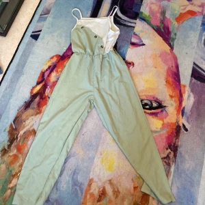 Mintgrön byxdress från Shein - Snygg mintgrön byxdress från Shein med smala axelband och knappar framtill. Byxdressen har resår i midjan och raka ben. Perfekt för dig som gillar en chill och trendig look. Materialet känns lätt och passar bra till varmare dagar. ( saknar band runt median)