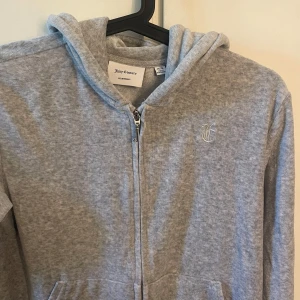 Grå Juicy Couture hoddie  - Grå hoddie från Juicy Couture. Storlek 15/16 år men passar en XS. Väldigt bra skick med nypris 1300kr