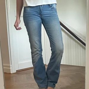 Bootcut jeans från &Denim ljusblå - Säljer ett par snygga ljusblå bootcut jeans från &Denim i storlek 32. Jeansen har låg midja, klassisk femficksdesign och är tillverkade i mjuk denim. Perfekta för dig som gillar en avslappnad men trendig look. De är i ett väldigt mjukt material och sköna att ha året runt#lågmidjade 