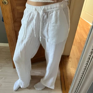 Vita linnebyxor med snörning - Säljer ett par vita linnebyxor. Byxorna har raka ben, sidfickor och en bakficka. Storlek xs