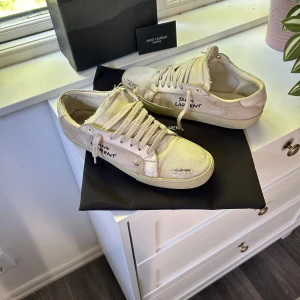 Saint Laurent skor - Tjena, säljer nu mina beige/vita saint Laurent skor. Skorna är i bra skick men en liten defekt under skon och på boxen då nån tejpat på boxen lite dumt,så därav priset! Kan gå mycket vid snabb affär! Skriv gärna om ni har några funderingar🤩💭