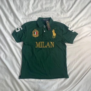 Chief Keef Milan M - 💚 Chief Keef Style Polo Ralph Lauren “MILAN” Polo – Storlek M 💚  Höj din stil med denna 🔥 Polo Ralph Lauren kortärmade polo — precis som den Chief Keef rockade! 💯 Mörkgrön med djärv MILAN-broderi i guld 🟡 för den där högljudda, iögonfallande looken.  🧵 Detaljer: 👕 Storlek: Medium (M) 🎨 Färg: Mörkgrön med gula och vita detaljer 🐎 Stor Polo-logotyp + broderat vapensköld #️⃣ Vita “3”-märken på båda ärmarna 🧼 Skick: Helt ny med etiketter 🏷️ 💯 Kraftiga streetwear-vibbar — klassisk passform, 100 % !