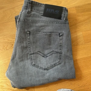 Grå Replay Grover jeans straight fit - Snygga grå jeans från Replay, modell Grover, med straight fit och klassisk femficksdesign. Jeansen har en stilren look med Replay-logga på bakfickan och är tillverkade i mjukt denimtyg. Perfekta för dig som gillar en rak passform och tidlös stil.