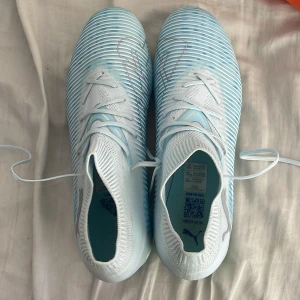 Puma ljusblå fotbollsskor strl 40.5 - Säljer ett par snygga fotbollsskor från Puma i ljusblått och vitt. Använda 2 träningar. Original pris 1100. Vid snabb affär kan pris diskuteras