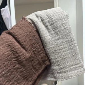 Brun och beige halsduk i bomull - Tvåfärgad halsduk i brun och beige med lätt skrynklig struktur. Tunt och mjukt material som känns luftigt och passar perfekt för lager-på-lager. Råa kanter ger en avslappnad vibe.