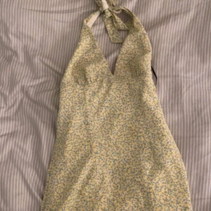 Gul blommig halterneck sommarklänning - Supersöt sommarklänning med halterneck, den e perfekt i längden och sitter jättefint på, säljs inte längre 