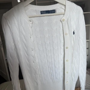 Vit kabelstickad kofta Polo Ralph Lauren - Vit kabelstickad kofta från Polo Ralph Lauren i bomull. Kvitto och prislapp finns kvar!