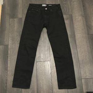 Svarta straight jeans från Dressmann - PRIS ÄR SATT. Svarta jeans från Dressmann med klassisk femficksdesign och raka ben. Jeansen har normal passform och är tillverkade i ett mjukt bomullsmaterial med lite stretch. Perfekta för dig som gillar en clean och enkel look.