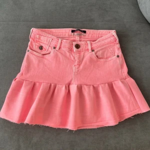 Lågmidjad rosa volangkjol  - Säljer en rosa jeanskjol med volanger som är lågmidjad 💗Midjemått 37 cm, längd fram 33 cm, längd bak 39 cm. Jag har sytt den själv, väldigt noga gjort.