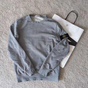 Stone Island tröja - Hejsan! Säljer denna sjukt snygga Stone Island sweatshirten då den inte kommer till användning! Passar mellan 152-160cm! Rätt så smal vid midjan!  | På bild 2 så ser man en liten färg fläck på vänster armen vilket sänker priset | ~Nypris: 4000kr | / | vårt pris: 549kr ✅ | självklart äkta! Nk påse medföljer via köp och priset kan diskuteras! 🥰