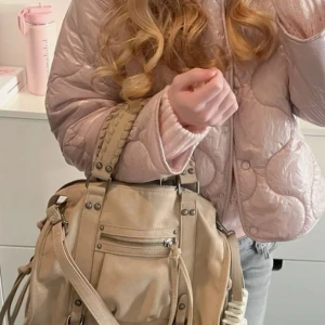 Bershka bowling bag - ÖPPEN FÖR BYTE MOT DEN I SVART.Snygg beige axelväska i skinnimitation med flätade handtag och coola metalldetaljer. Väskan har dragkedja framtill, flera fack och långa dekorativa remmar på sidorna. Perfekt storlek för att få plats med allt du behöver och passar till många olika outfits. Aldrig använd för att jag insåg att den inte skulle komma till användning när jag fick hem den💗💗 kommer i original förpackning, köpt för 450kr
