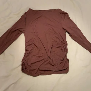 Smutsrosa långärmad topp med rynk från Mywear - Säljer en smutsrosa långärmad topp från Mywear i mjuk bomull. Tröjan har snygga rynkade detaljer på sidorna. Storlek S