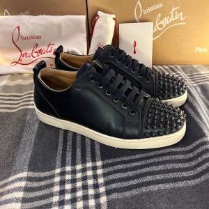 Christian Louboutin skor - Tjaaaa allihop just nu så säljer jag ett par mörkblå sneakers i läder från Christian louboutin. Skorna är i galet bra skick och har endast använts två gånger ute. Självklart är skorna äkta som man ser på bilderna, men kan även bevisa äktheten på fler sätt. ny pris för skorna är runt 900 €. Till skorna tillkommer en replacement box från Loubotin då jag gjorde mig av av den andra på grund av slitage samt dustbag. Jag tar gärna byten som vanligt och också prisförslag.  Med vänliga hälsningar Oscar