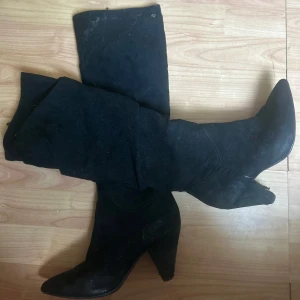 Svarta stövlar med klack och spetsig tå - Säljer ett par svarta höga stövlar med snygg spetsig tå och markerad klack. Dom  är gjorda i mocka, stilrena boots.