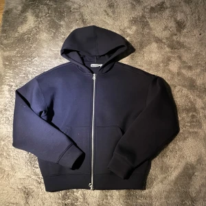 Scuba hoodie - Snygg mörk blå hoodie från Weekday i storlek XS. Tröjan har huva, långa ärmar och en rejäl dragkedja framtill. Praktiska fickor på magen och mjukt material som känns skönt mot huden. Perfekt för chill dagar eller när du vill ha en enkel och clean look.