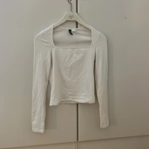 Vit långärmad topp från Divided - Säljer en stilren vit långärmad topp från Divided med fyrkantig halsringning. 