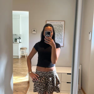 Leopardmönstrad kortkjol med volang - Supersnygg kortkjol med leopardmönster och bred, smockad midja. Kjolen har volangkant som ger en extra cool och trendig look. Jag köpte denna i spanien och är använd vid få tillfällen. Jag brukar vika ner midjan så den bli lågmidjad. Står tyvär ingen torlek men kan passa upp till M.