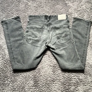 Gråa Replay jeans, storlek 28W 32L - 28W, 32L Snygga Replay Waitom jeans i grå med klassisk femficksdesign och raka ben. Jeansen har coola detaljer som Replay-logga på fickan och metallknapp framtill. Passformen är slim fit. Perfekt för dig som gillar den stilren med avslappnad look. Nya: 800 kr
