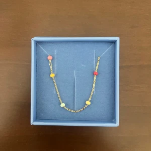 Färgglatt armband från Enamel Copenhagen - Supersött armband i guld från Enamel Copenhagen med små pärlor i rosa, rött, gult och ljusblått. Säljer pågrund av att den inte kommer till användning. Aldrig använd!