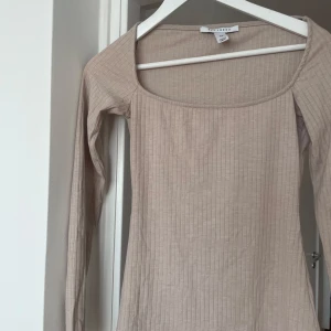 Beige ribbad långärmad topp NLY Trend - Säljer en beige långärmad topp från NLY Trend i storlek XS. Toppen har en fyrkantig urringning och är ribbad 