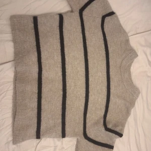 Stickad tröja – helt ny, oanvänd, Xs - Stickad tröja – helt ny, oanvänd, XS Beige stickad tröja med svarta ränder. Aldrig använd, i perfekt skick. Mysig och varm – passar utmärkt för höst och vinter. Ifrån Ginas premium kollision   Perfekt för dig som gillar enkel men snygg stil och vill ha något som är både skönt och trendigt 