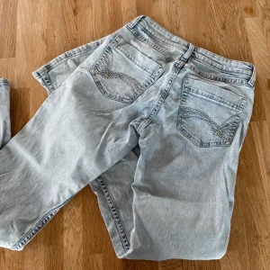 Bootcut ljusblå jeans med broderade fickor - Säljer ett par ljusblå bootcut jeans med snygga broderade detaljer på bakfickorna. Klassisk femficksmodell med knapp och dragkedja framtill. Jeansen har en avslappnad passform och är lågmidjade. Använt skick & en liten missfärgning som syns på bild.🤍 Innerben: 75 Midja: 34 men lite stretchig Gren: 19🤍 