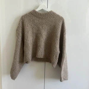 Beige croppad stickad tröja Gina Tricot - Säljer en beige stickad tröja från Gina Tricot i storlek XS. Bra passform, väldigt mysig och varm. Är i bra skick och använd ett fåtal gånger