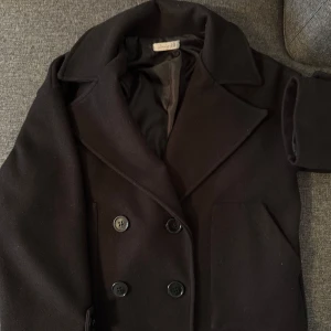 Svart kappa från Design by Si - Säljer min älskade svarta kappa från Design by Si i storlek XS/S. Den är välanvänd men ser ut som nyskick eftersom den är väl omhändertagen och vi använt noppbortagare. Köpt för 750kr säljer för 400kr💗