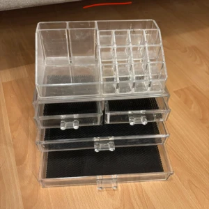 Transparent sminkförvaring med lådor - Snygg och praktisk sminkförvaring i transparent akryl med flera fack och utdragbara lådor. Perfekt för att organisera sminkborstar, läppstift, ögonskuggor och andra sminkprodukter. Kommer i delar som kan staplas eller användas separat.