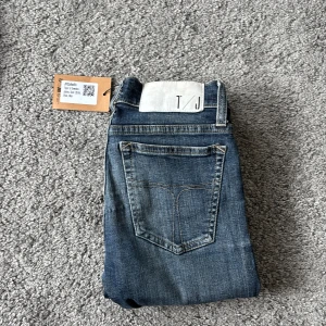 Blå skinny jeans från Tiger of Sweden - Snygga blå jeans från Tiger of Sweden i modellen skinny med klassisk femficksdesign och diskreta slitningar. Jeansen har normal passform och är tillverkade i jeansmaterial med en cool tvättad look. Perfekta för dig som gillar stilrena och smala jeans.