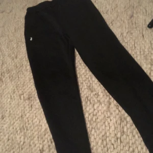 Svarta mjukisbyxor med polo logga - Svarta mjukisbyxor från Polo Ralph Lauren med en liten vit broderad logga på vänster höft. Byxorna har en klassisk, avslappnad passform och är gjorda i mjukt bomullsmaterial. Perfekta för chill eller utekvällar. Lite loose fit