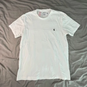 Vit T-shirt från Polo Ralph Lauren - Säljer en vit T-shirt från Polo Ralph Lauren, i helt nytt skick, T-shirten är i storlek 170 (S).  Mått 📏📐 - Bröstvidd 44cm  - Bottenvidd 45cm - Plagglängd 60cm  Hör gärna av er vid frågor  ~ LoopSupply ~ 