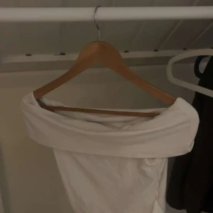 Vit offshoulder tubtopp Pull&Bear - Säljer en vit offshoulder tubtopp från Pull&Bear i storlek M. Toppen har en bred, vikt kant upptill som ger en snygg offshoulder-look. Perfekt för dig som gillar minimalistisk stil och vill ha en enkel men trendig topp till sommaren.