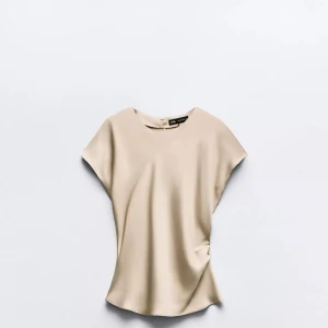 Beige blus från Zara i sidenlook - Supersnygg beige blus från Zara med rund hals och korta ärmar. Aldrig används 