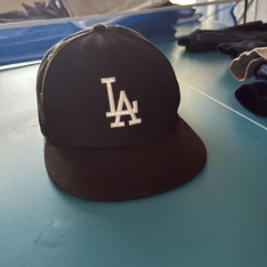 Svart LA keps  - En svart La keps helt okej skick haft ett tag den är för liten därför jag säljer den. Inga hål, bara lite lite sliten. 