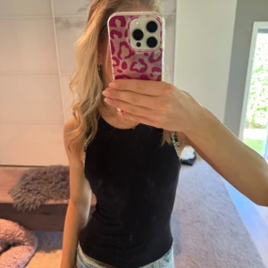 Svart ärmlös linnetopp - Snygg svart linnetopp från bershka med rund hals och tight passform. Perfekt att matcha med jeans eller kjol för en clean och enkel look. Toppen är ärmlös och har en klassisk stil som funkar året runt. Toppen är knappt använd och har inga defekter💕