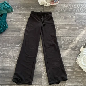 Svarta mjukisbyxor från 57 i XXS - Svarta mjukisbyxor från 57 i storlek XXS. De har en bred resår i midjan med snörning och raka, lite vidare ben. Materialet är mjukt och skönt, perfekt för chill dagar. Snygg och enkel design som funkar till hoodies eller t-shirts.