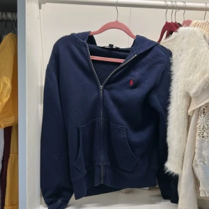 Mörkblå hoodie från  Ralph Lauren - Jättesnygg tröja från Ralph Lauren!❣️Tyvärr har den lite fläckar på framsidan men det går säkert att ta bort, dragkedjan är även lite svår att dra upp då en grej på den har åkt av❣️ Storlek 10-12 ❣️ Pris kan absolut diskuteras ❣️!