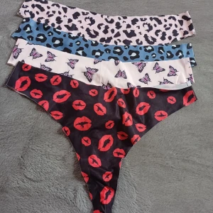 Färgglada trosor med olika mönster - Säljer ett set med fyra färgglada trosor i olika mönster: leopard, fjärilar och läppar. Tillverkade i mjuk polyester och elastan för en bekväm passform. Perfekt för att liva upp underklädeslådan!