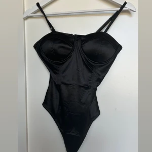 Svart body  - Svart body med justerbara axelband och  dragkedja. Storlek S. Formade kupor med push up, säljer för den va tyvärr lite för stor för mig 🤍