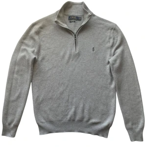 Grå Half zip - Polo Ralph Lauren - Säljer en grå halfzip från Polo Ralph Lauren i mjuk pima bomull. Tröjan har en dragkedja vid halsen och långa ärmar.