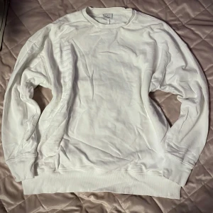 Vit sweatshirt från Gymshark - Säljer en stilren vit sweatshirt från Gymshark. Tröjan har en klassisk design med ribbade muddar och rund hals. Perfekt för en avslappnad look eller träning. 🏋️‍♂️storlek L men mer av en XL
