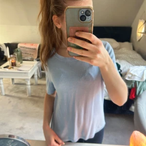 Ljusblå stickad topp - Säljer en ljusblå stickad topp med korta ärmar. Perfekt för en avslappnad stil. Toppen har en rund halsringning och är gjord i ett mjukt material.