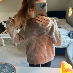 Brun stickad tröja  - Mysig brun stickad tröja med långa ärmar och dekorativa knappar på sidan, från indiska. Helt oanvänd, nypris runt 300kr. 