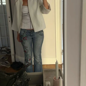Broderade jeans med blommönster - Säljer nu mina URSNYGGA vintage jeans som är heeeeeelt perfekta till våren nu😍🌟Bra skick! Köpta vintage i Paris för 1 år sedan. Midjemått: 39 cm tvärsöver Innerbensmått: 85 cm Total-längd: 104 cm. Storlek M, skulle säga att de sitter som en S/M. HAR INGA FLER BILDER❤️