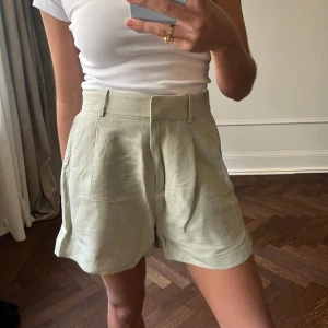 Gröna shorts i linneblandning - Snygga gröna shorts från H&M i en skön linneblandning. De har en hög midja och stängs med dragkedja och knapp. Perfekta för varma sommardagar!