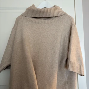 Beige stickad polotröja - Beige stickad polotröja som är trekvartsärmad 